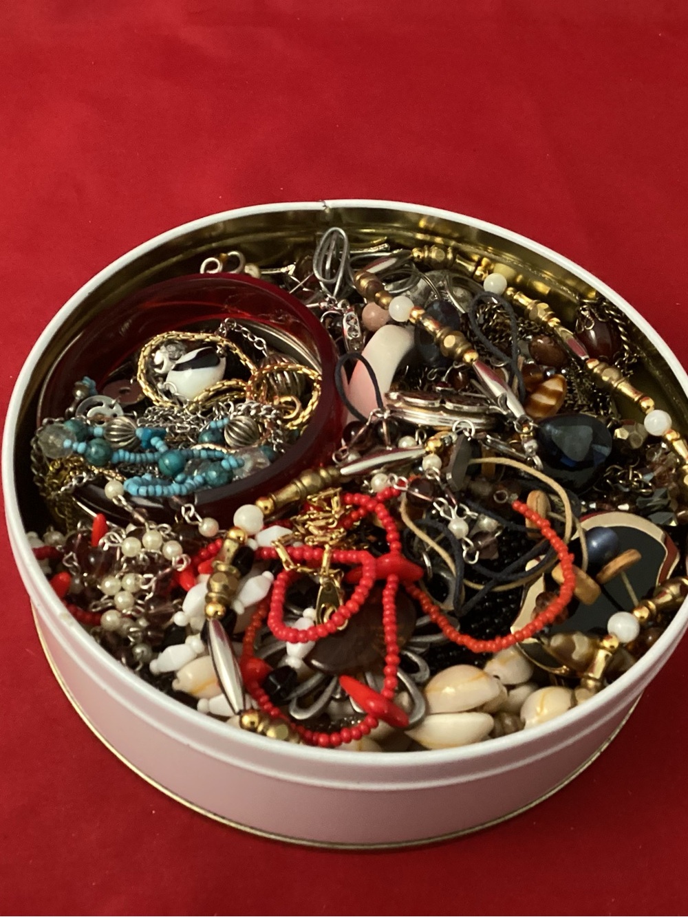 Assorted costume jewelry in a tin box